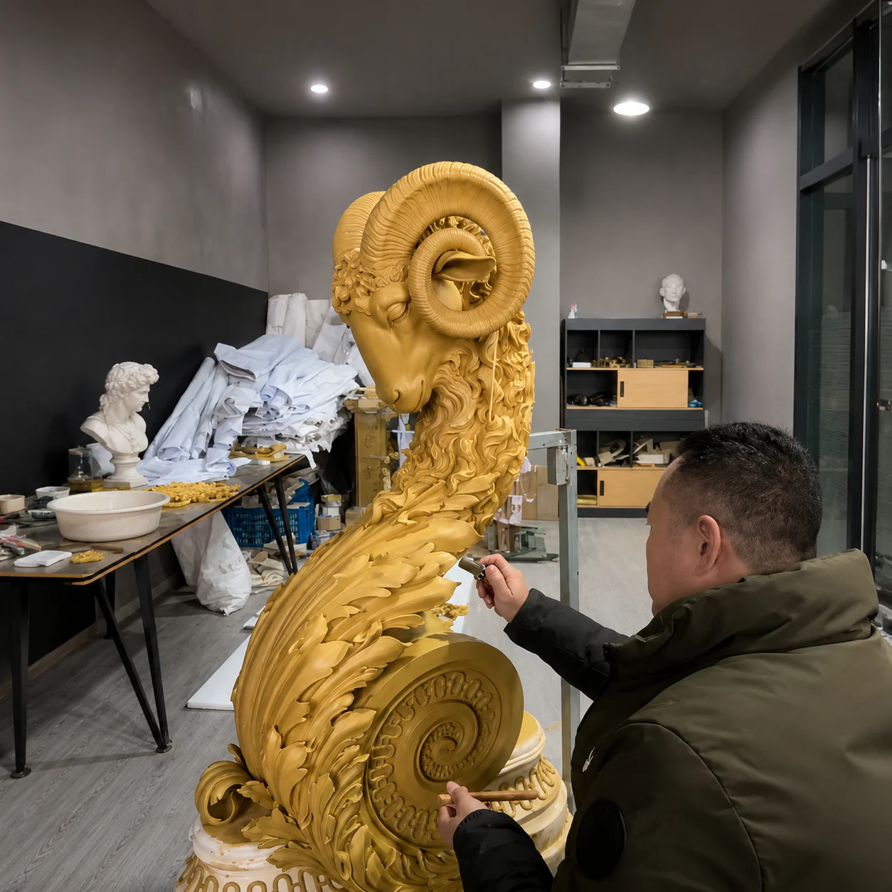 An artisan refining the details of a sculpted ram